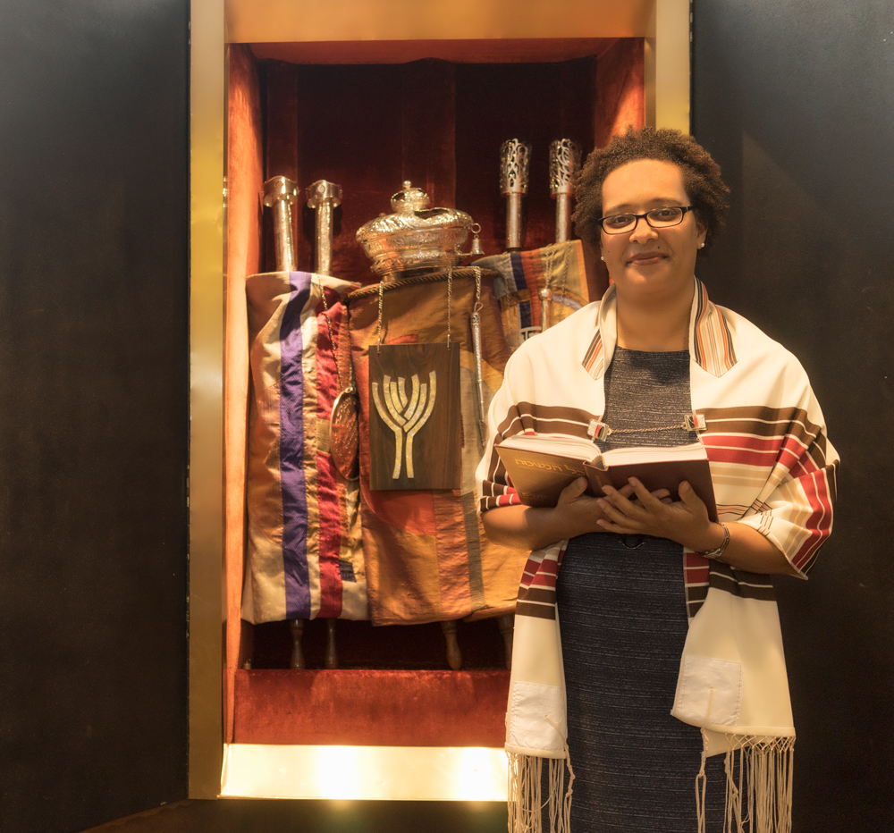 Rabbi Georgette Kennebrae standing in front of aron kodesh